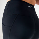 Close-up of the high waistband and curved seams on black PTP Pace Microweighted Leggings.