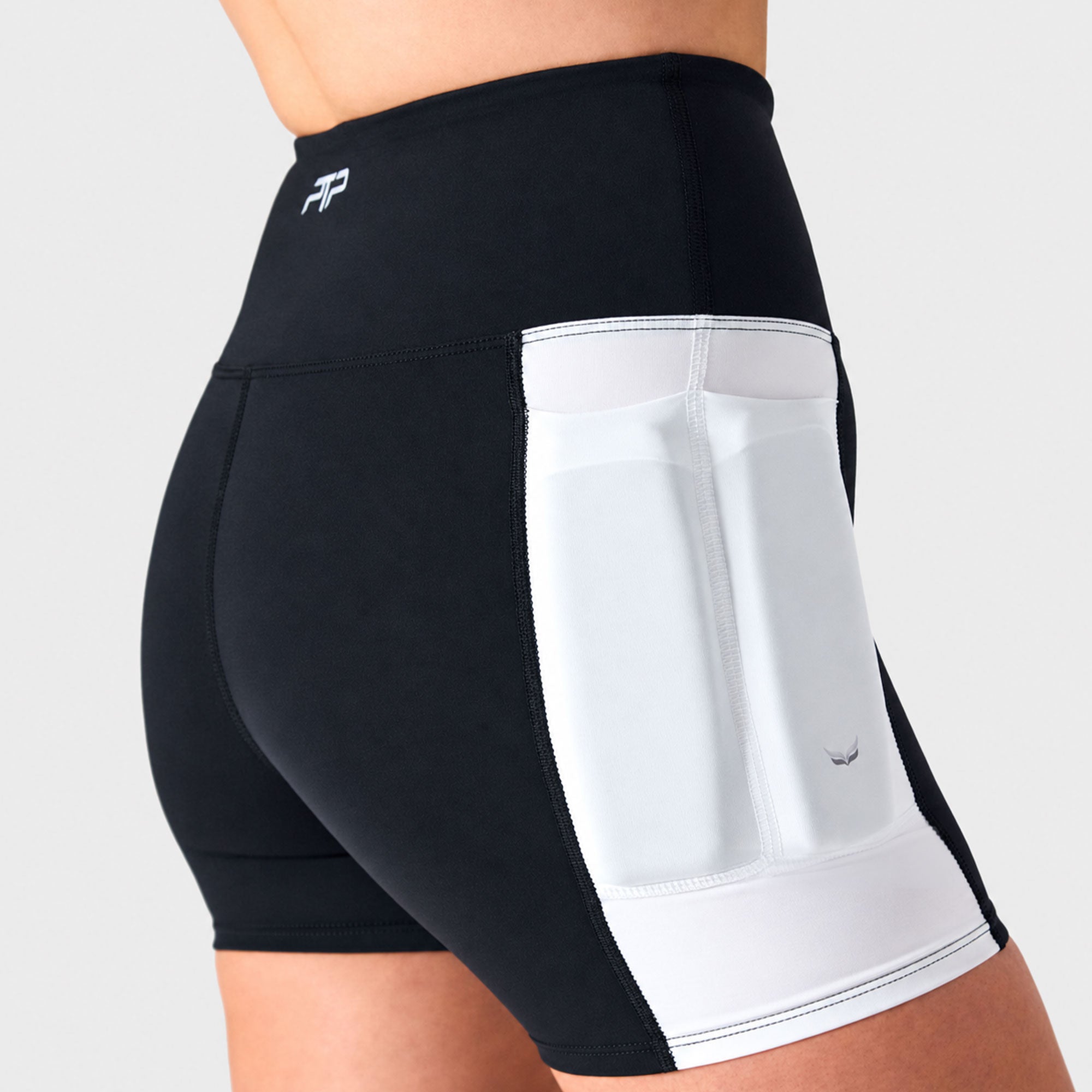 Side view of black PTP Form Microweighted Shorts worn by a woman, showing the white thigh weight pocket.