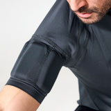 Close-up of a man wearing a dark gray athletic compression sleeve on his upper arm, showing the textured fabric and seam details.