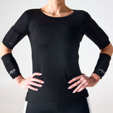 Woman wearing black PTP Motion Microweighted Arm Bands on both forearms, with hands on hips.