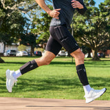 Man running on a park path while wearing black PTP Motion Microweighted Calf Sleeves.