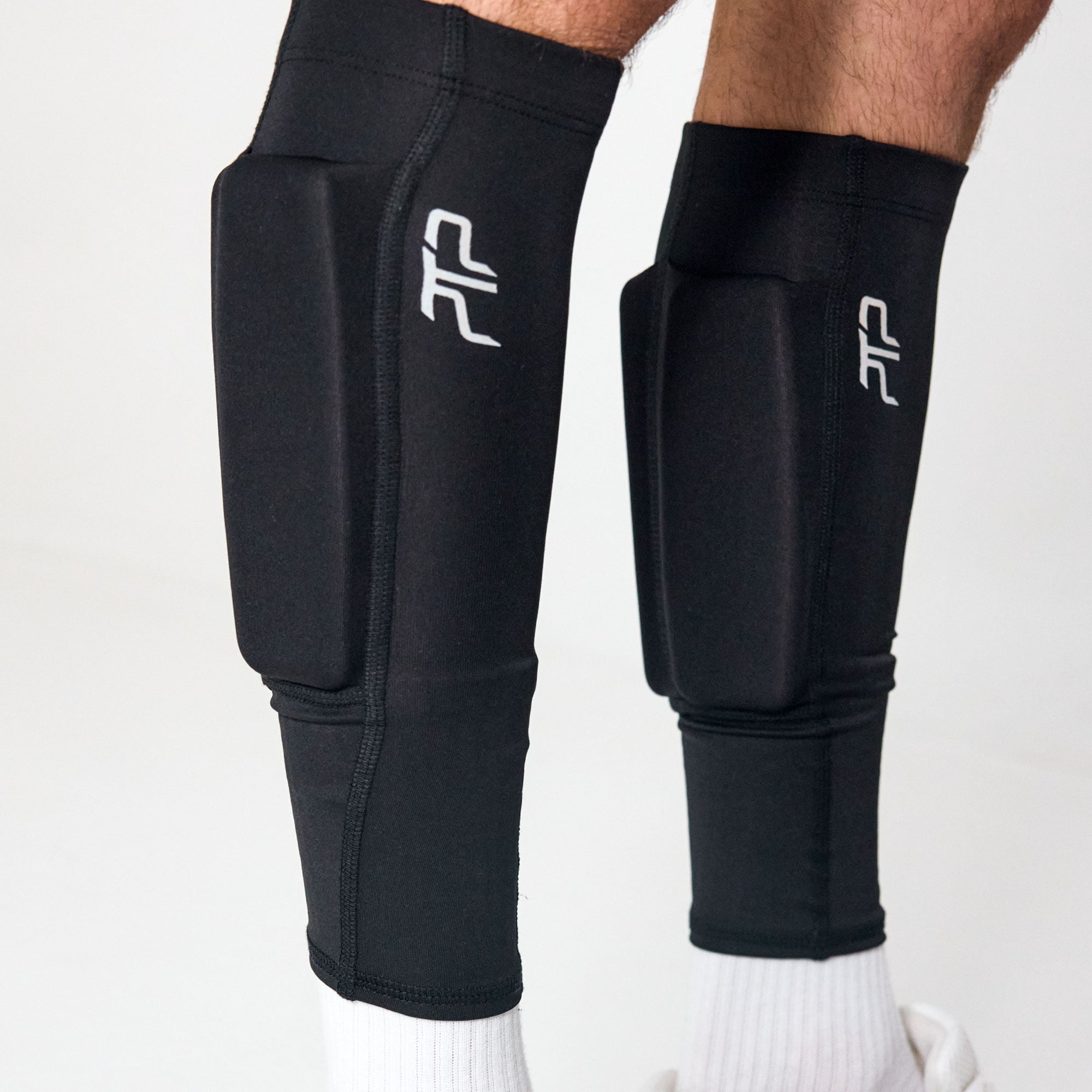 Close-up of black PTP Motion Microweighted Calf Sleeves worn on both legs.