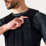 Close-up of a man inserting a pocket weight into the front of a black PTP Plyoslide Microweighted Vest.