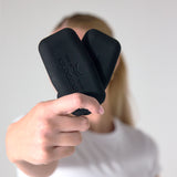 Person holding two black PTP Small Pocket Weights towards the camera.