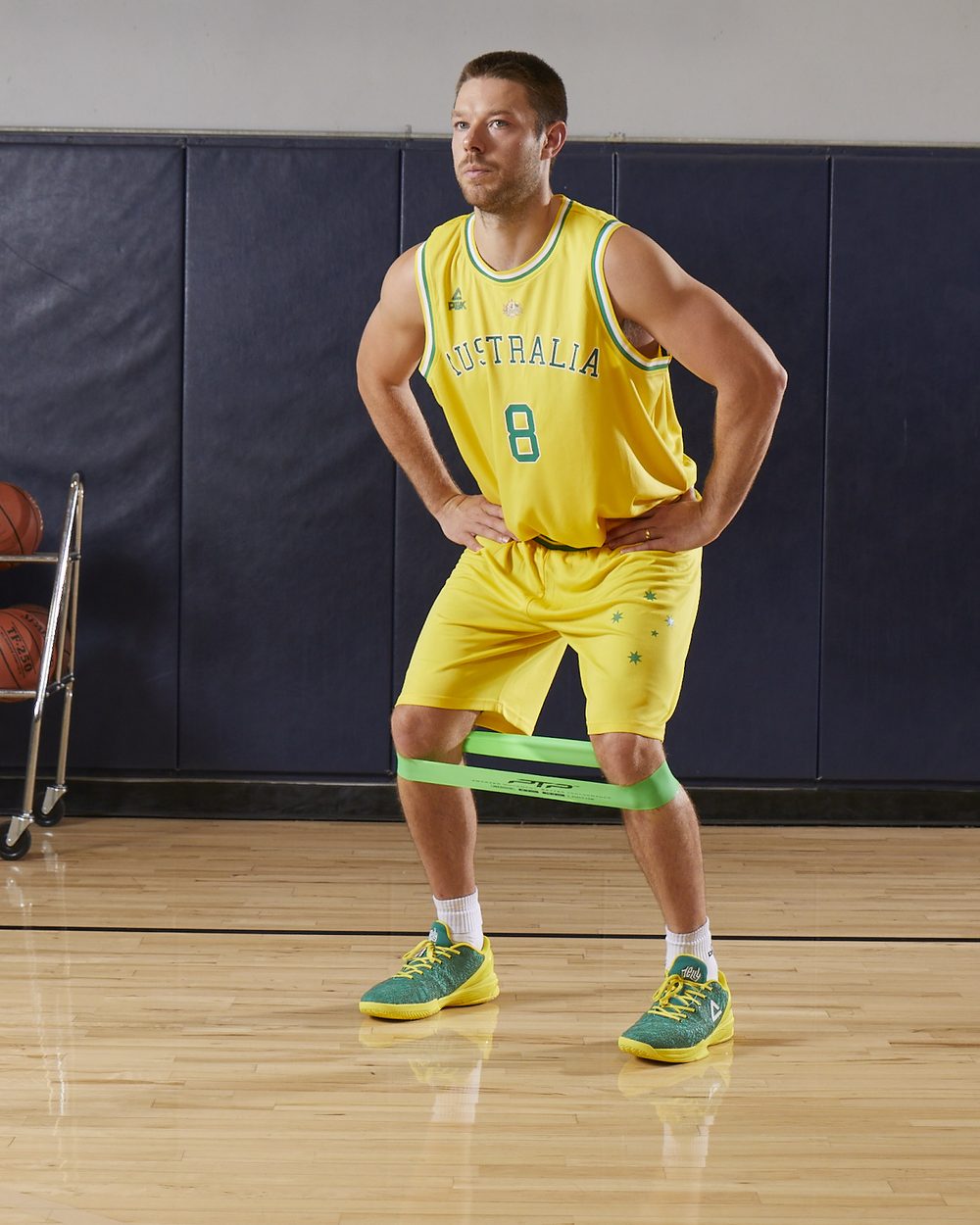 Matthew Dellavedova in the Australian Boomers kit with a green PTP mini band around his shins, ready for a lateral band walk