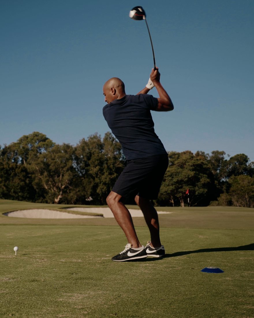 Golfer at the top of his backswing on a sunny tee